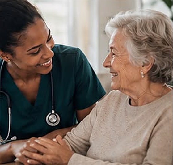Pflegefachkraft im Gespräch mit einer älteren Patientin